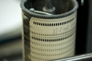 Metallzylinder mit ca 5 cm Durchmesser auf dem eine weisse Lochkarte für die Steuerung des Lochkartenstanzers benötigt wird